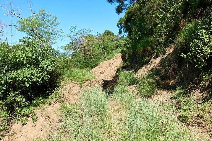 Mountain dirt road ending in landslide