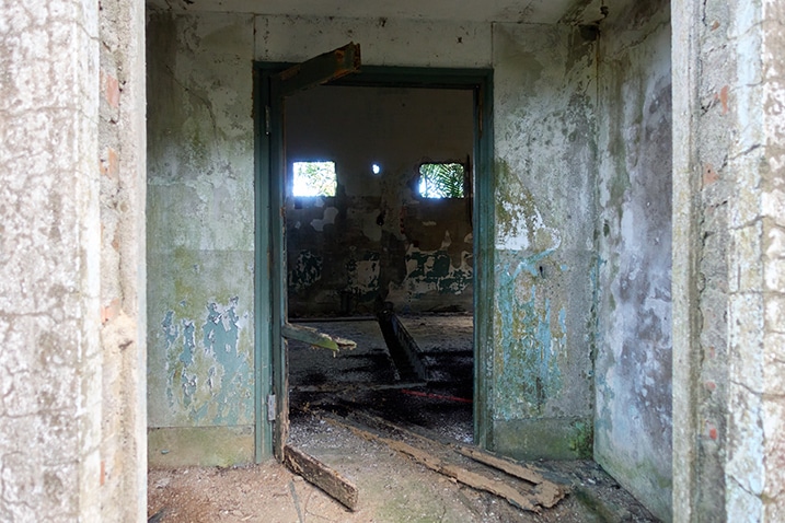 looking inside abandoned concrete building - doorway - doors have fallen and disappeared