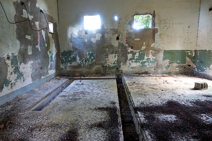 Abandoned room - two windows and door frames - bat scat on the floor - channels dug into floor