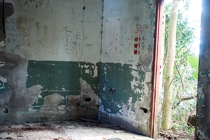Corner of abandoned room - door to the right - graffiti on walls