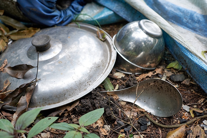 Closeup of metal spoon, bowl, and pot lid