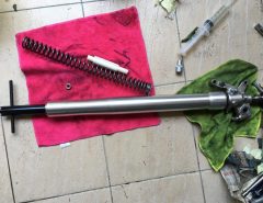 Motorcycle fork and spring on towel on tile floor