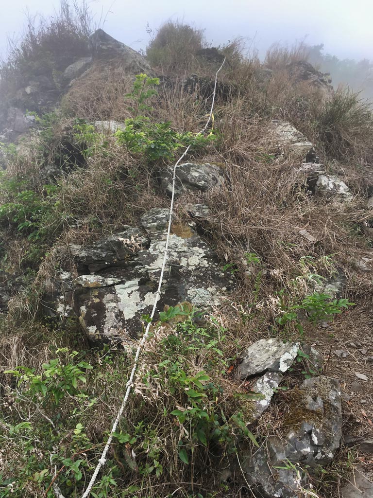 Rope climb up rocky ridge