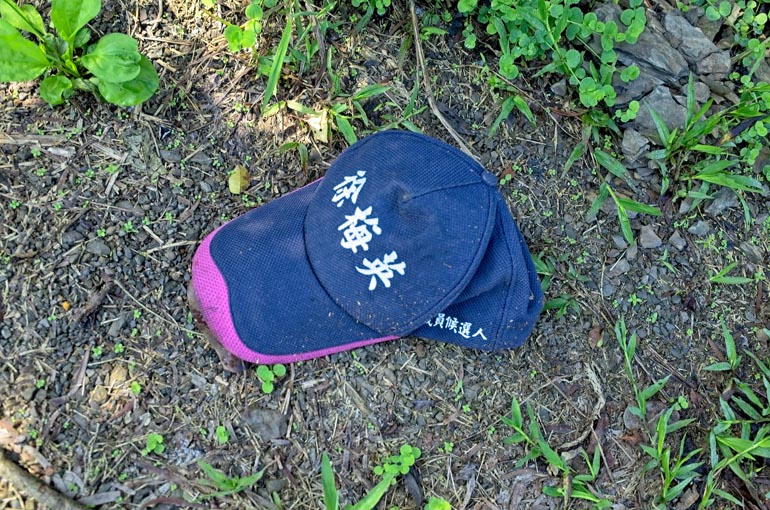 Baseball cap on ground with Chinese words written on it