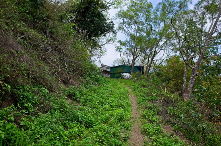 Mountain trail leading to destroyed green structure