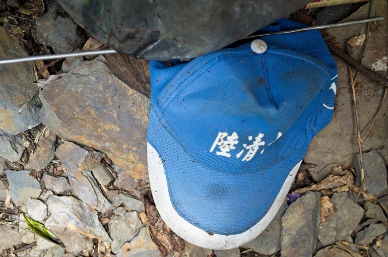 Blue cap with white Chinese writing lying on the ground