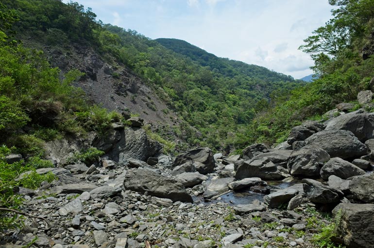 Riverbed view with waterfall behind - rocky