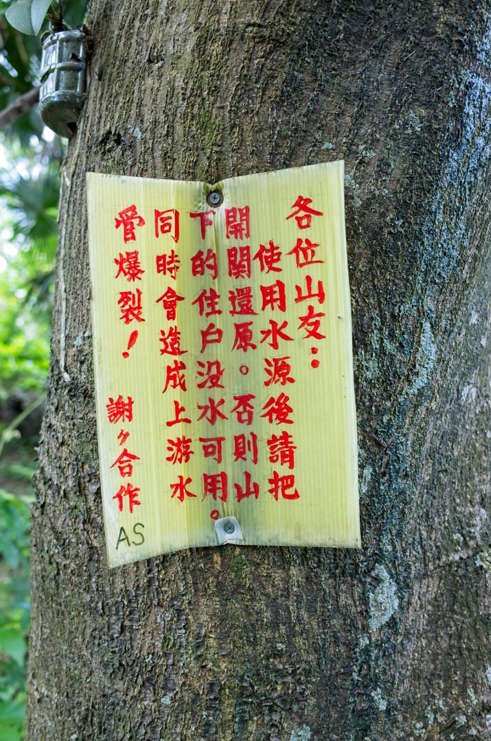 Sign in Chinese - red letters - nailed to tree