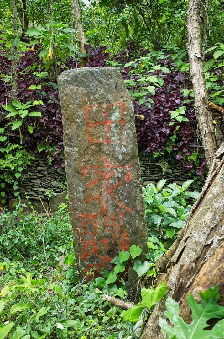 Large tall thin upright stone with words written in paint
