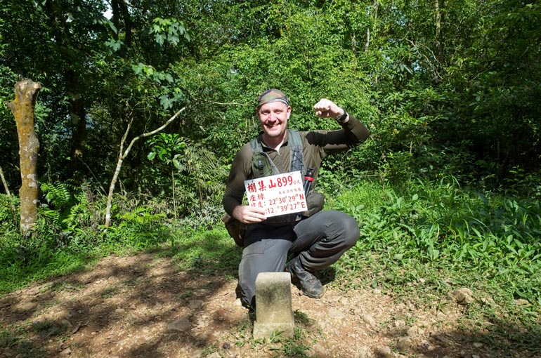 Me holding the pengjishan sign in triumphant pose in front of triangulation point