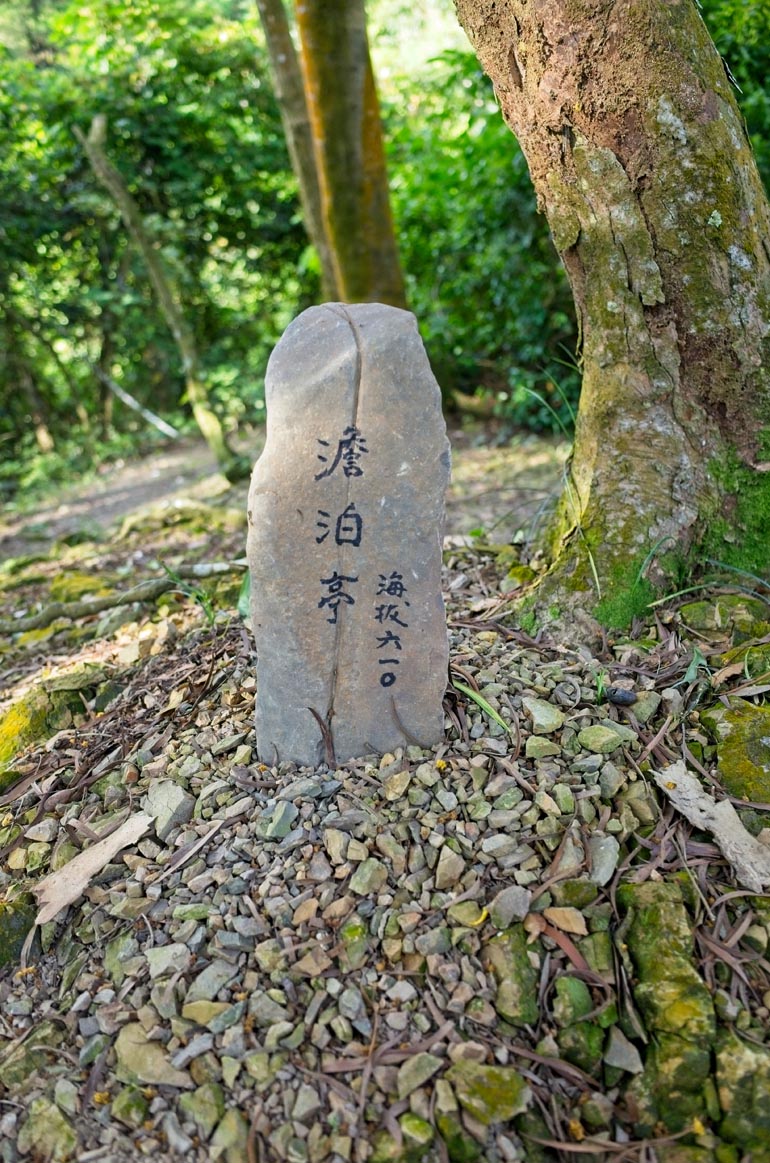 Upright stone placed in the ground with Chinese writing on it