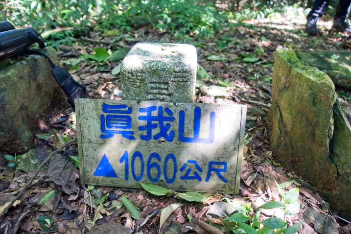 真我山 Zhenwoshan triangulation marker with peak sign leaning against it