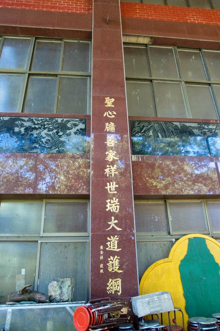 Windows and carving in side of building - Chinese words written down side