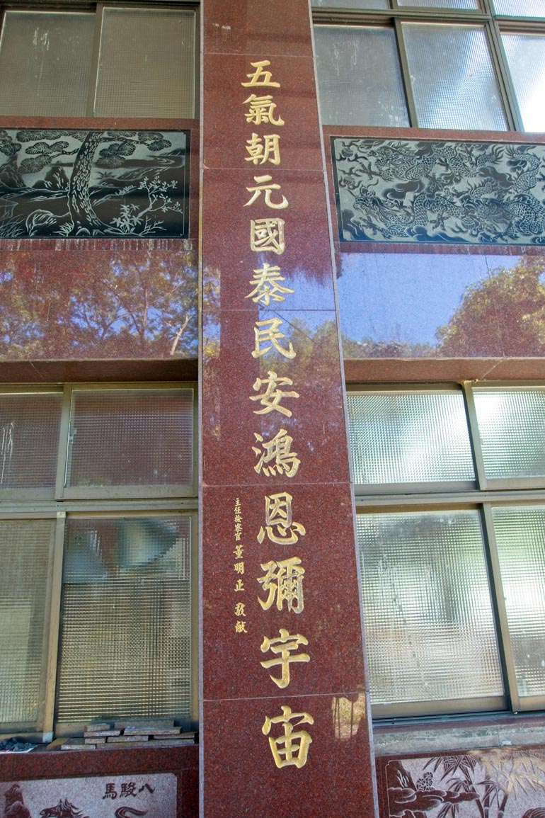 Windows and carving in side of building - Chinese words written down side