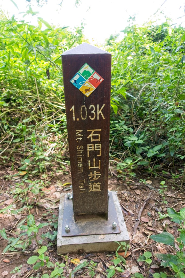Wooden pillar with 石門山 written on it and some other info - concrete base