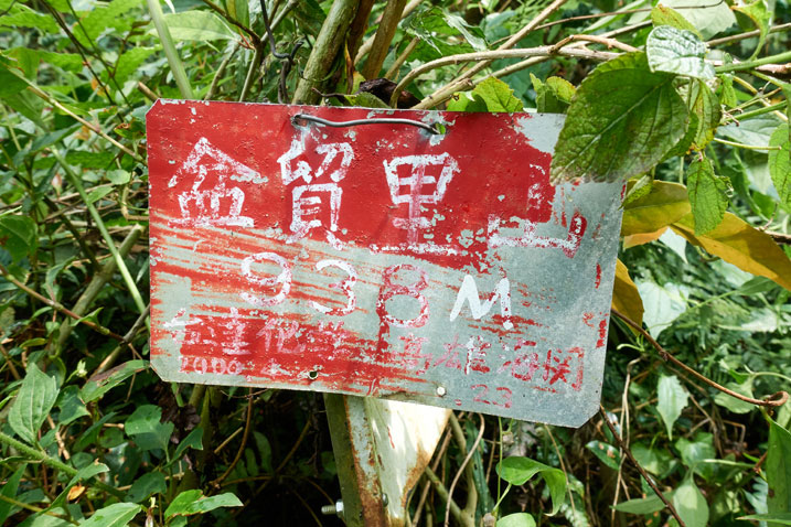 Red sign nailed to another sign - Chinese writing