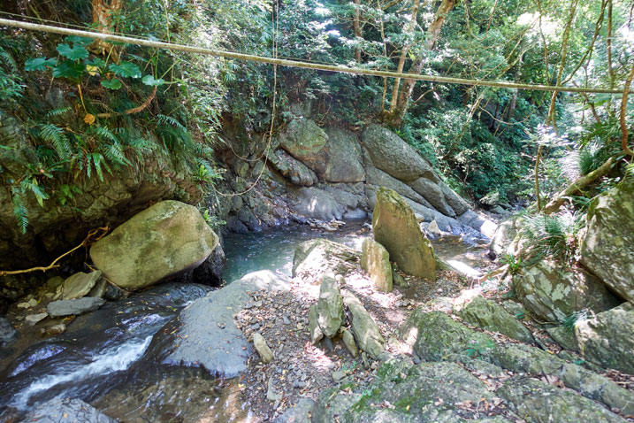 Rocky stream - trees next to stream - old PVC pipe strung up over the stream