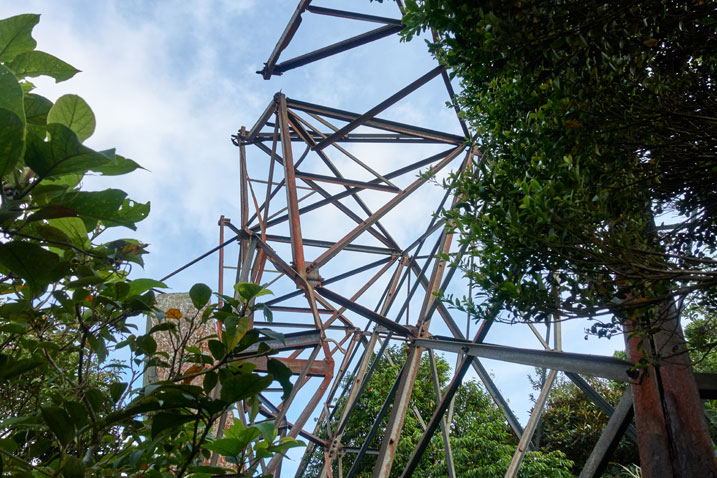 metal beam structure - broken - trees to side - blue skies above