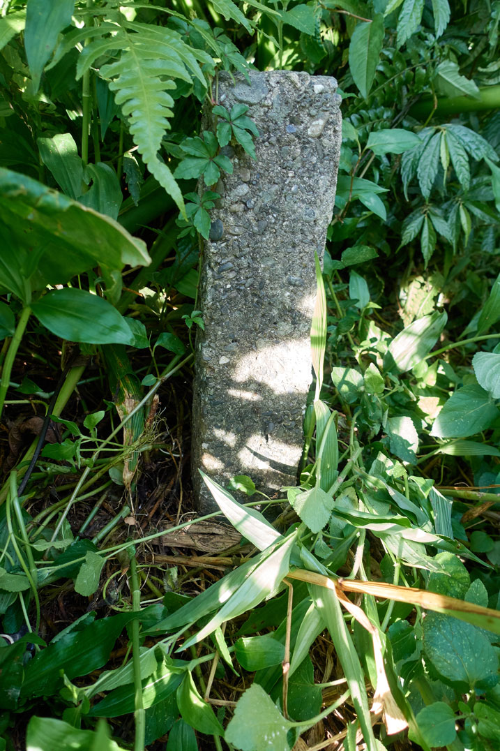 An older style concrete marker in the ground