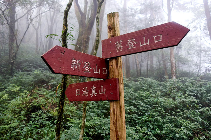 Three red signs on a wooden pole