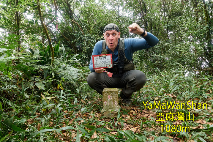 Man kneeling behind triangulation stone in triumphant pose