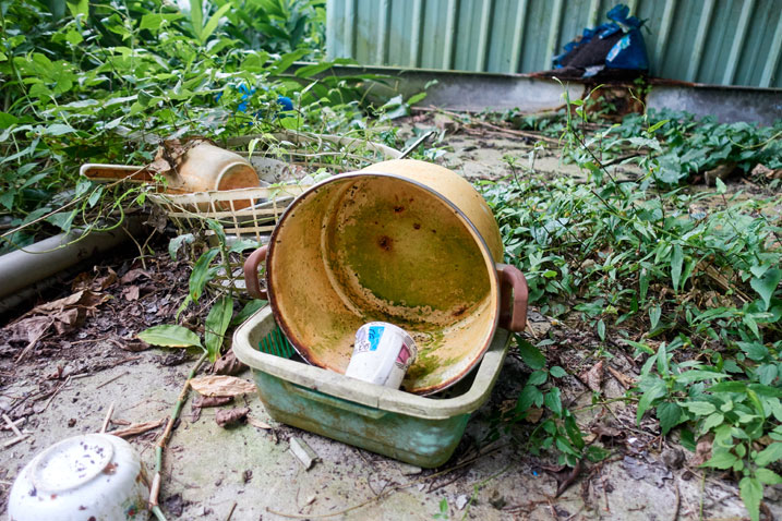 Old plastic bucket and dishware on concrete slab