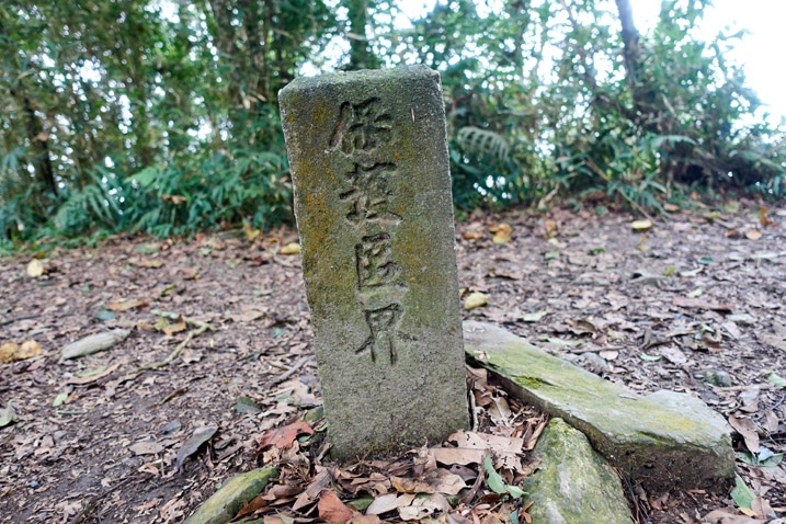 Stone marker stickout out of ground with Chinese writing