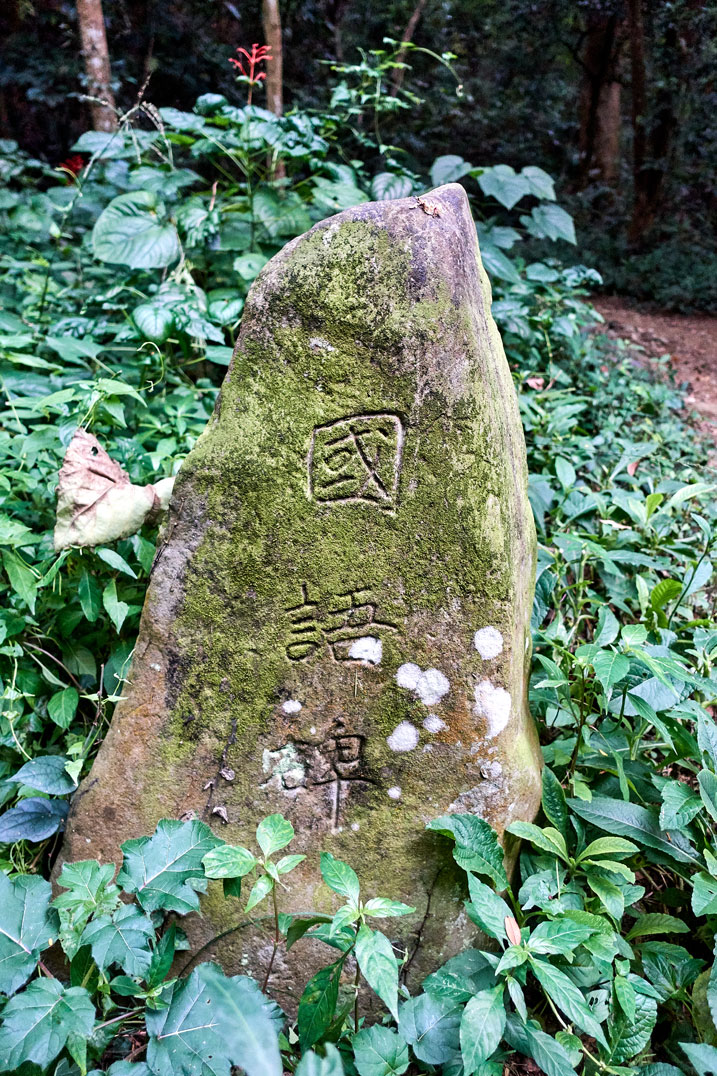 Large stone upright with Chinese words chiseled on it 