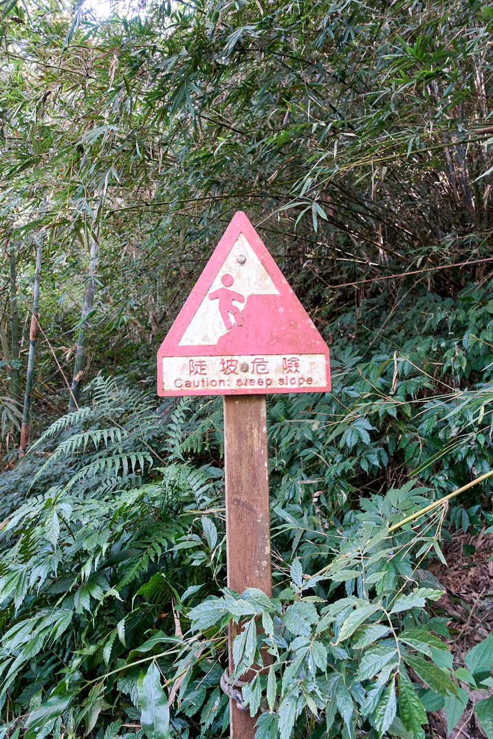 Red, triangular-shaped sign warning of steep slope - WeiLiaoShan Hike – 尾寮山