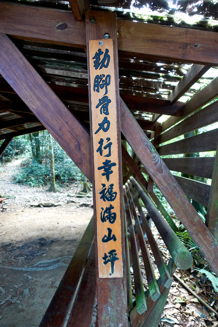 Long up and down wooden sign with chinese writing attached to a wood plank - WeiLiaoShan Hike – 尾寮山