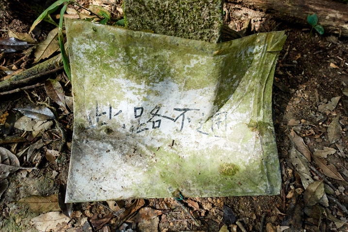 A moldy paper sign with Chinese writing - WeiLiaoShan 尾寮山 trail