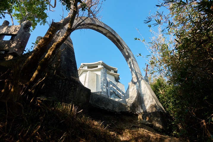 Looking up at a circular arch opening - white building behind it - 旗月縱走 - 旗尾山