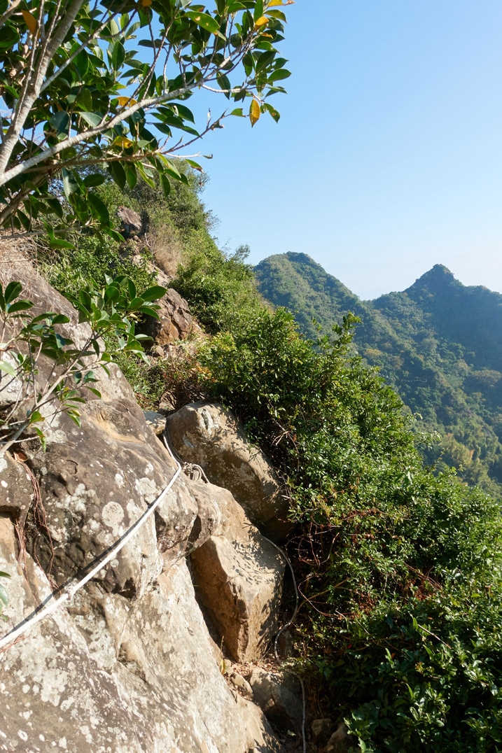 Rocky rope section of trail with mountains in backround - 旗月縱走