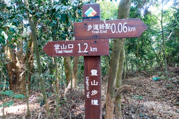 Wooden sign post with signs written in Chinese - 靈山步道 - 旗月縱走