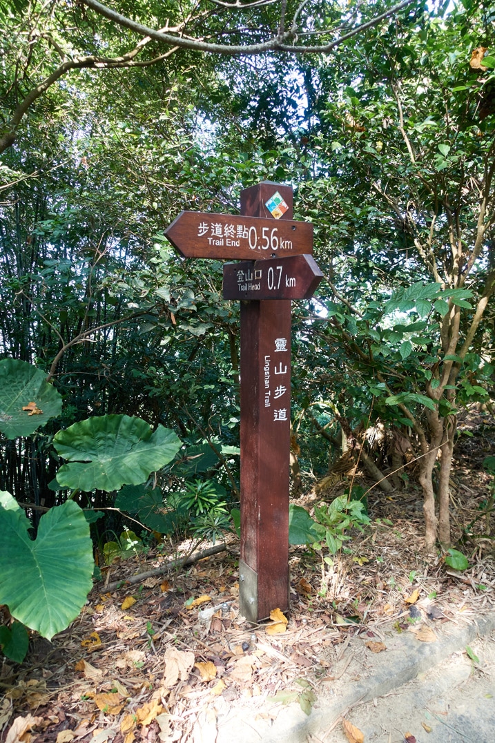 Sign post with two signs in Chinese attached - 靈山步道 - 旗月縱走