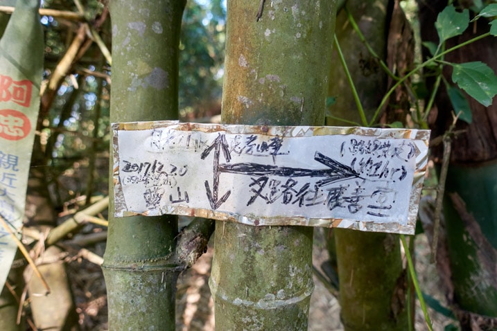 Sign attached to a bamboo tree in Chinese - 旗月縱走