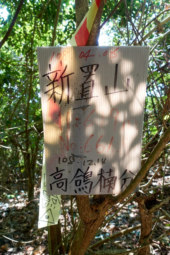 Plastic sign with Chinese writing at XinZhiShan - 新置山 Peak
