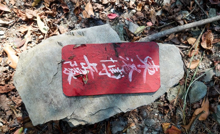 Red sign in Chinese on top of rock