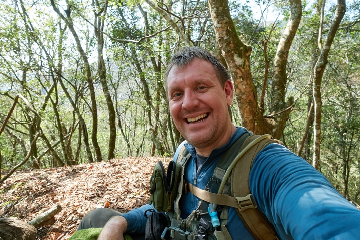 Man posing for selfie on mountain ridge trail