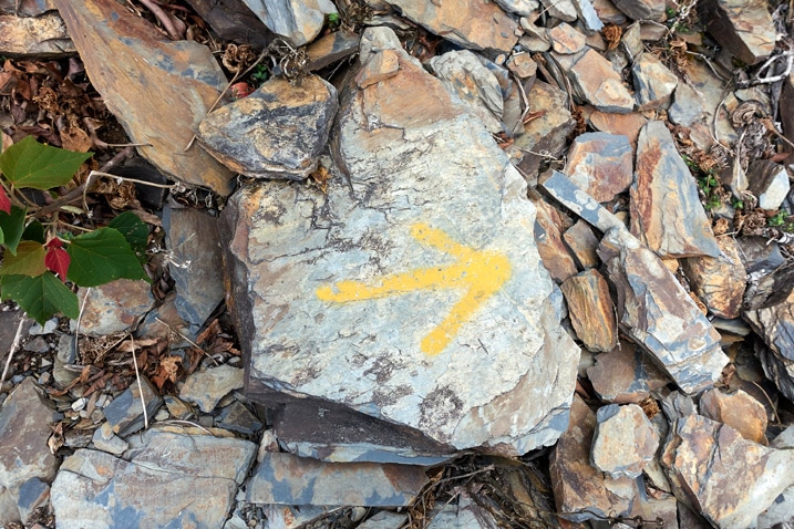 Rock with yellow arror spray painted on it