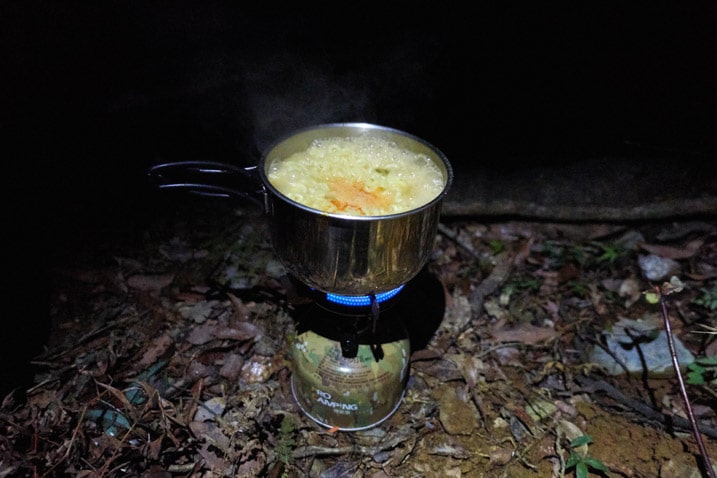 Camp stove cooking instant noodles in small pot