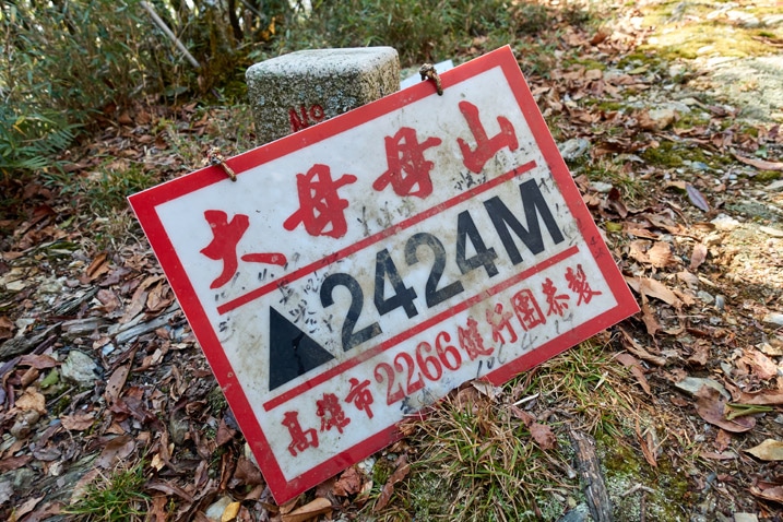 Triangulaiton stone with white sign with Chinese writing on it