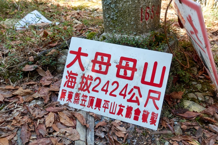 Triangulation stone with white sign with chinese writing on it