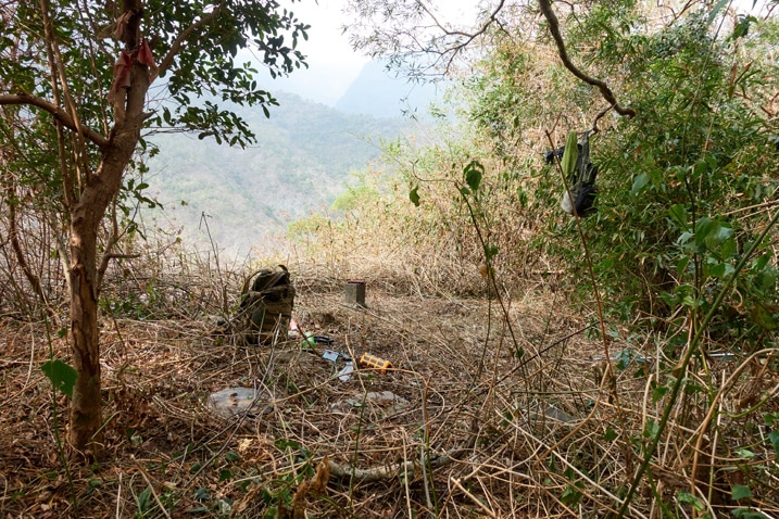 QiJiaXiShan – 七佳溪山 triangulation stone in cleared area - backpack and other items strewn about