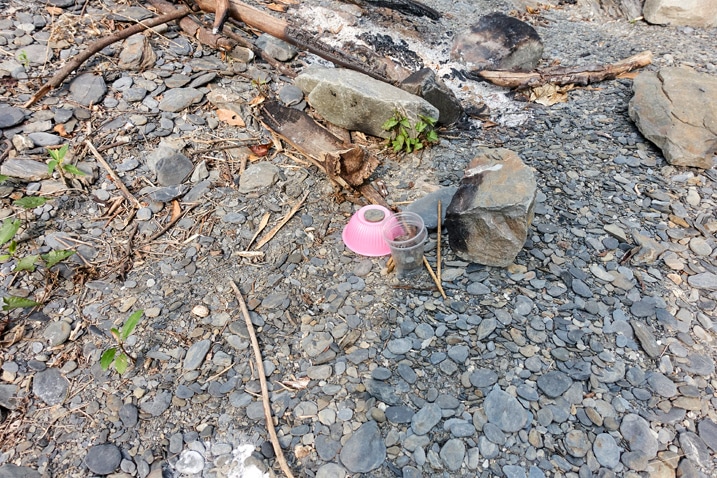 Pink plastic bowl discarded on riverbed