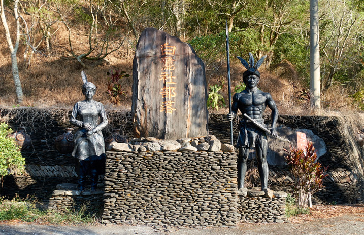 Taiwan aboriginal monument - large stone pillar flanked by aboriginal warrior and female