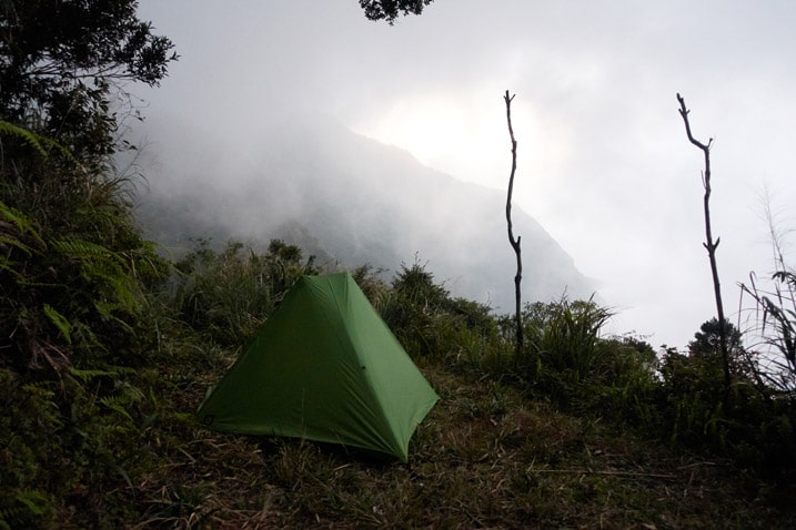 Green tent on edge of mountain - fog in background