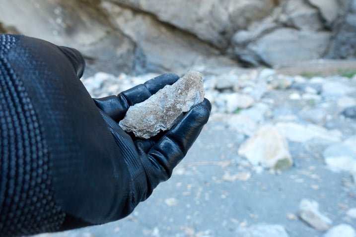 Gloved hand holding rock shard