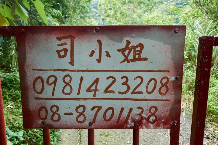 Sign on gate with name and phone number - written in Chinese