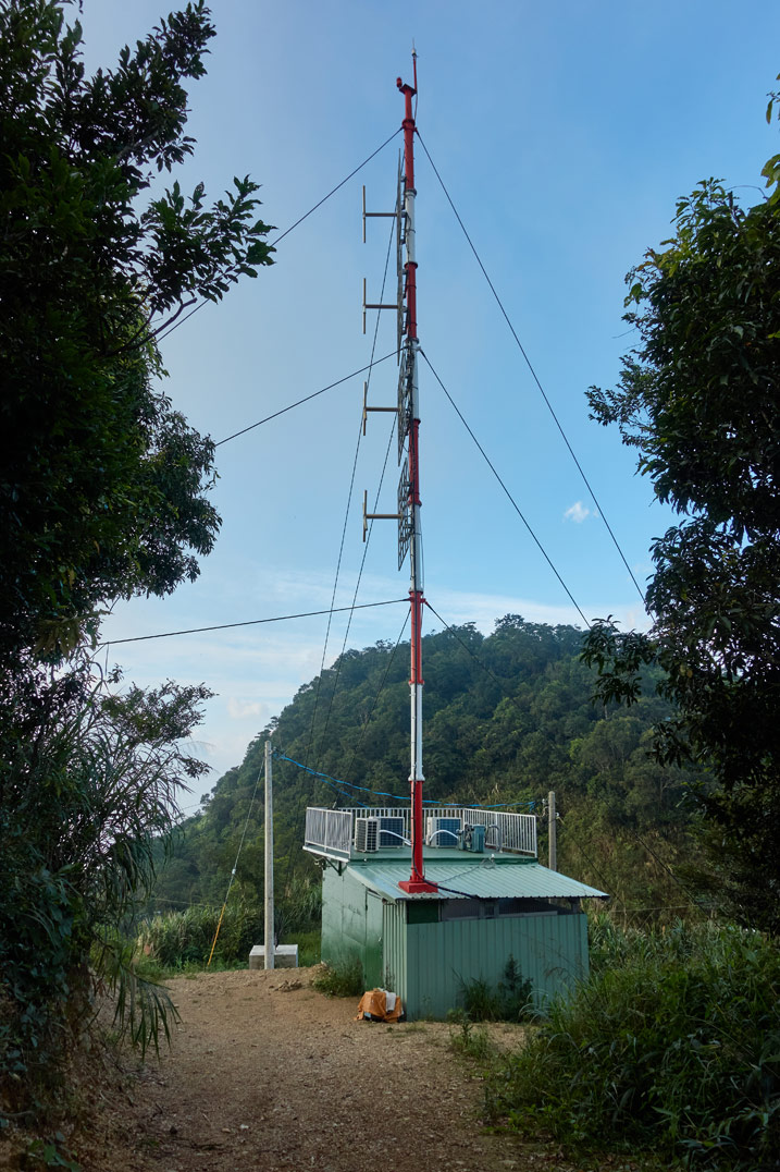 Radio antenna coming out of a small building - mountain in distance